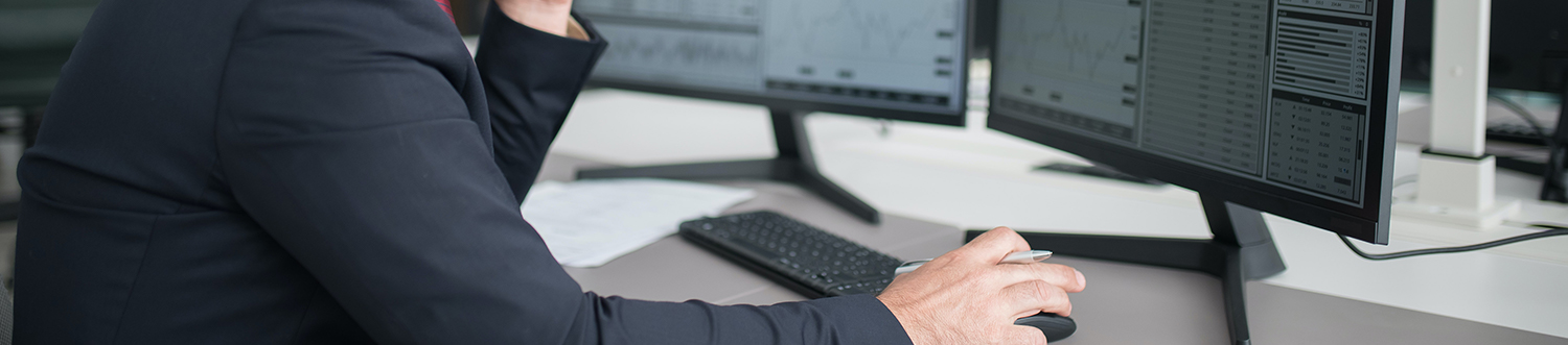 Ein Mann im Anzug vor dem Computer im Büro